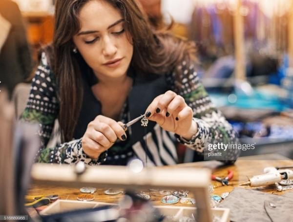 Dark haired woman crafting at a table