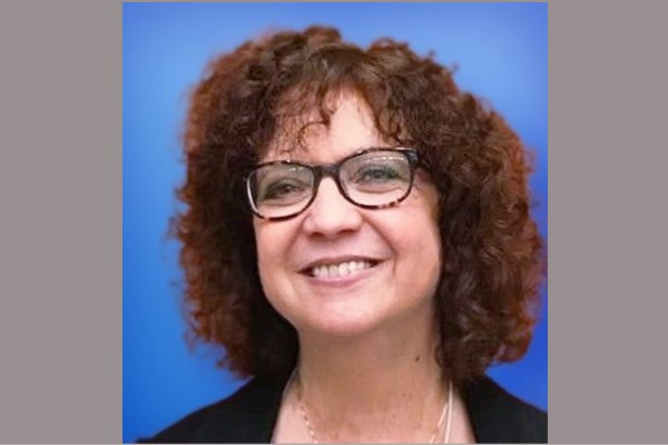 portrait of woman with glasses and curly hair smiling