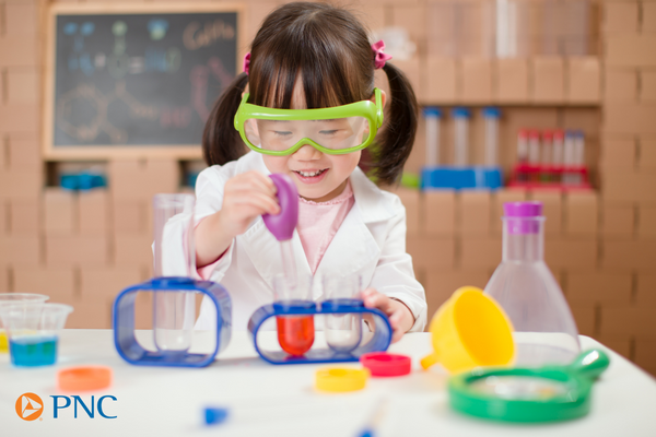 girl with glasses using science kit