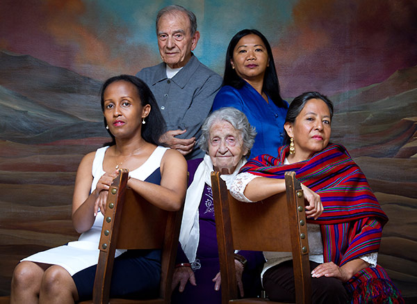 five people of different races and gender sitting for a portrait