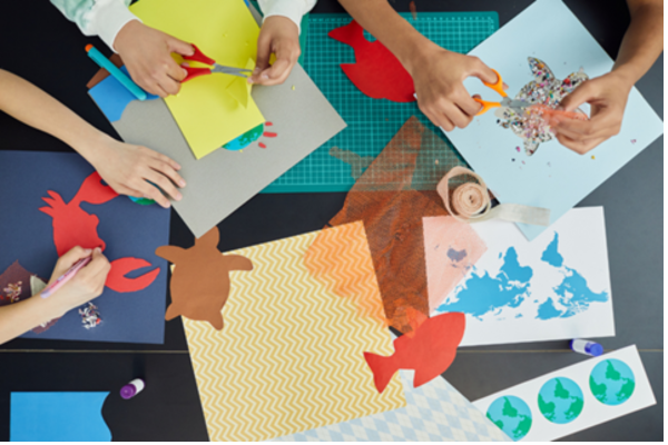 kids gluing cutouts on construction paper